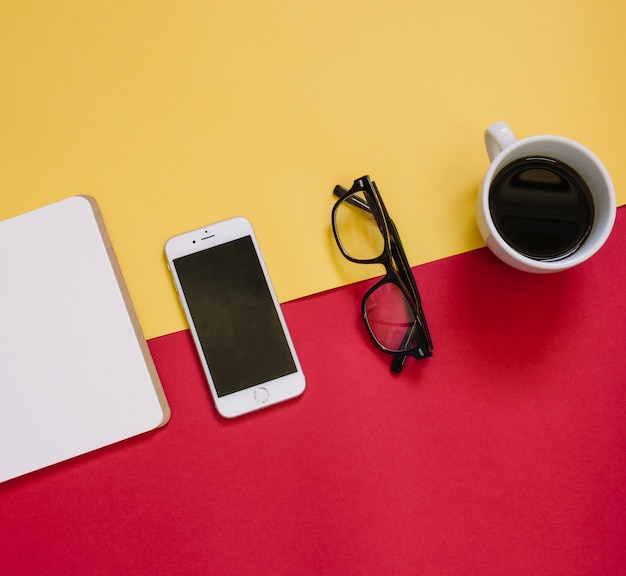 Gafas cerca de teléfonos inteligentes y café