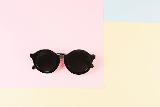 Foto gratuita gafas con estilo en el fondo en colores pastel