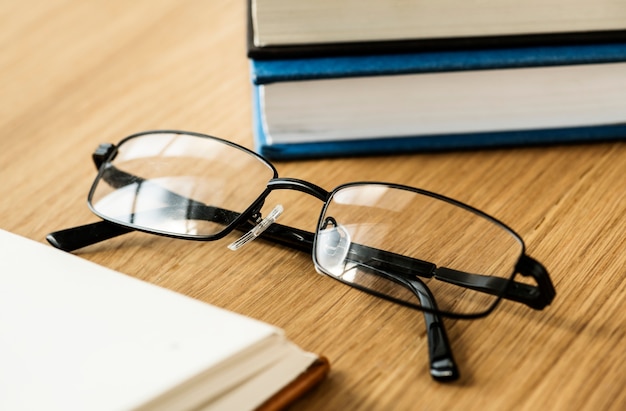 Unas gafas y libros de concepto educativo, académico y literario.