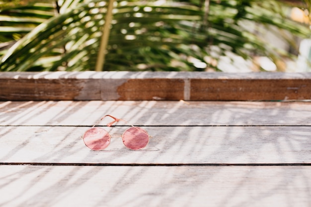 Gafas de mujer con estilo en la mesa de madera.