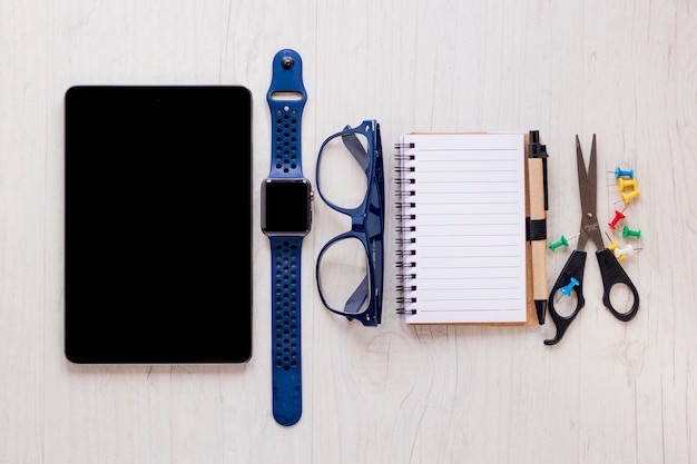 Gafas y reloj en medio de suministros de oficina