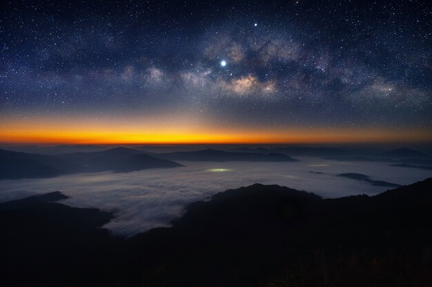 Galaxia de la vía láctea y estrella sobre las montañas.