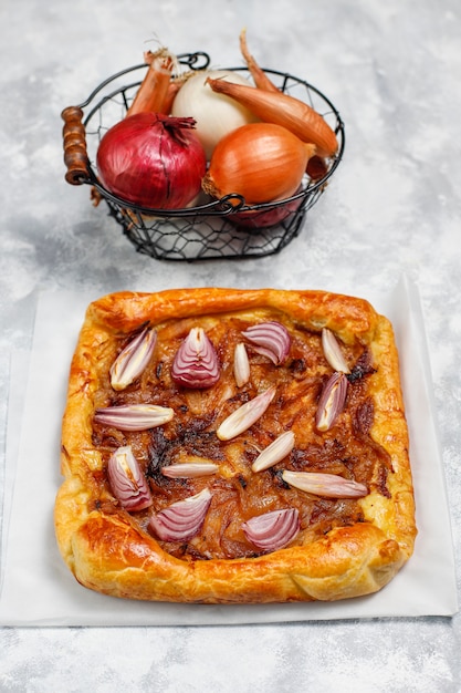 Galette de pastel de cebolla estilo francés con hojaldre y cebolla chalota, cebolla roja, blanca, amarilla, vista superior