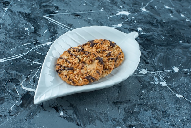 Foto gratuita galleta casera en un plato, sobre la mesa azul.