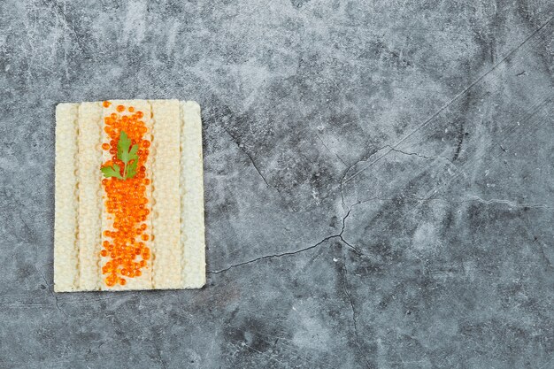 Galleta con caviar rojo.