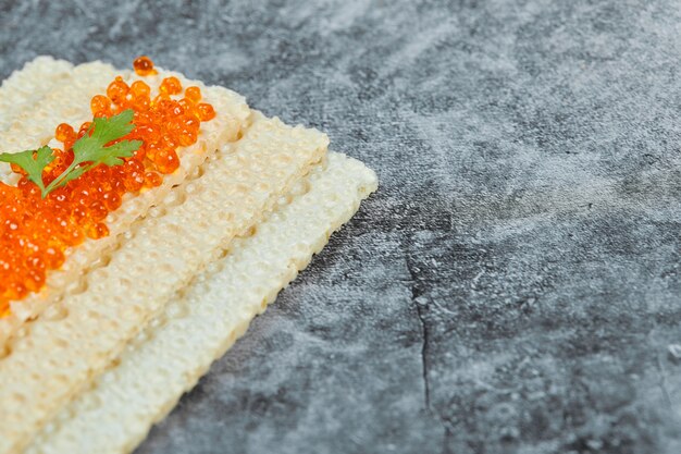 Galleta con caviar rojo.