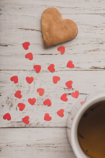 Foto gratuita galleta con corazones rojos y una taza