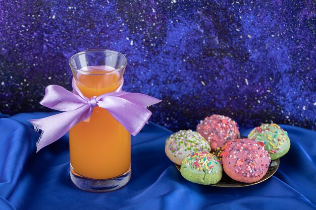 Galleta decorada con caramelos y vaso de jugo.