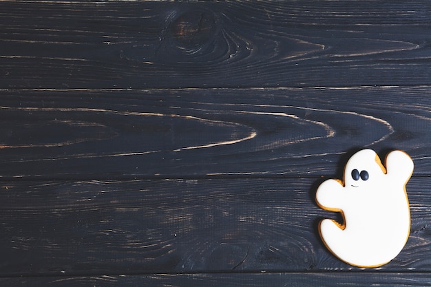 Galleta fantasma de Halloween en la mesa de madera negra