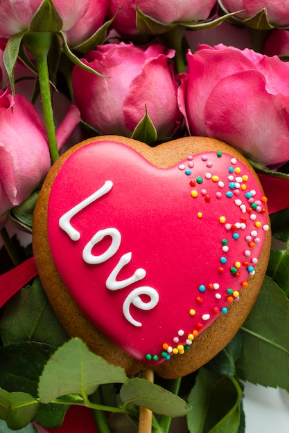 Galleta en forma de corazón en ramo de rosas