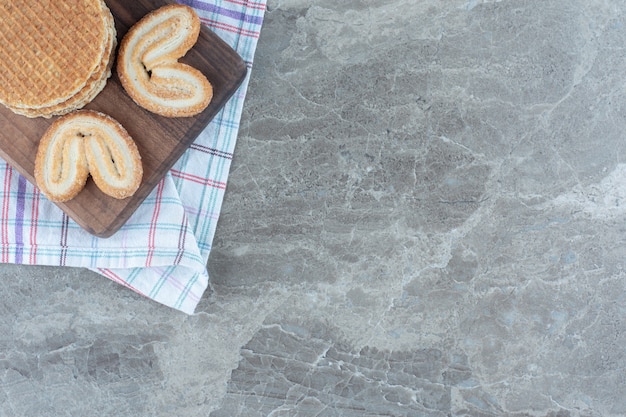 Galleta con galleta sobre tabla de madera sobre fondo gris.