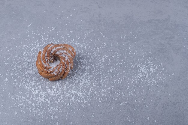 Una galleta sobre un montón de vainilla en polvo sobre la superficie de mármol
