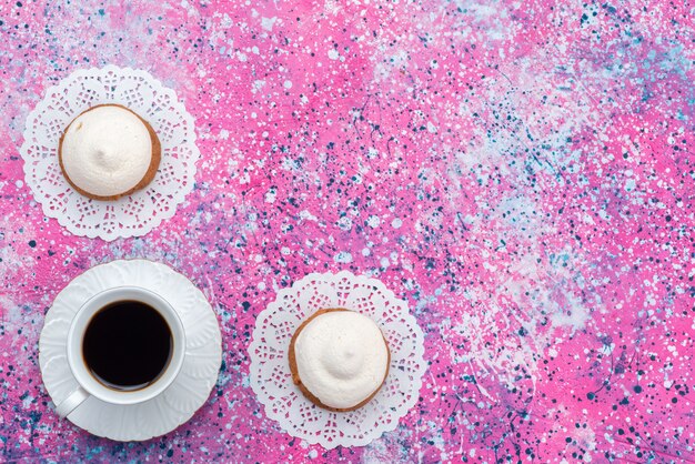 Galleta de vista superior con crema junto con una taza de café en el fondo de color pastel bsicuit azúcar dulce hornear