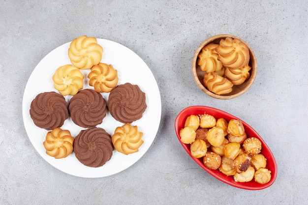 Galletas agrupadas en varios vajillas sobre superficie de mármol.