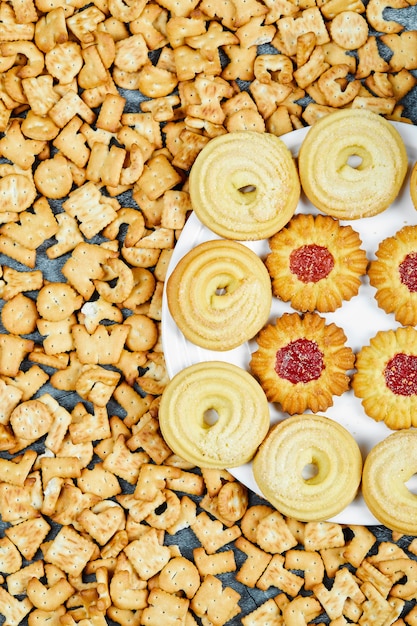 Foto gratuita galletas del alfabeto dispersas y un plato de galletas en el cuadro azul.