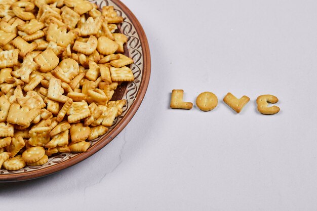 Galletas del alfabeto en una placa de cerámica y la palabra amor deletreada con galletas.