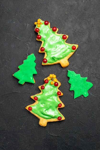 Galletas de árbol de navidad de vista superior en superficie oscura aislada año nuevo