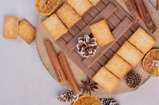 Galletas con aroma canela en rama en placa de madera. Foto de alta calidad