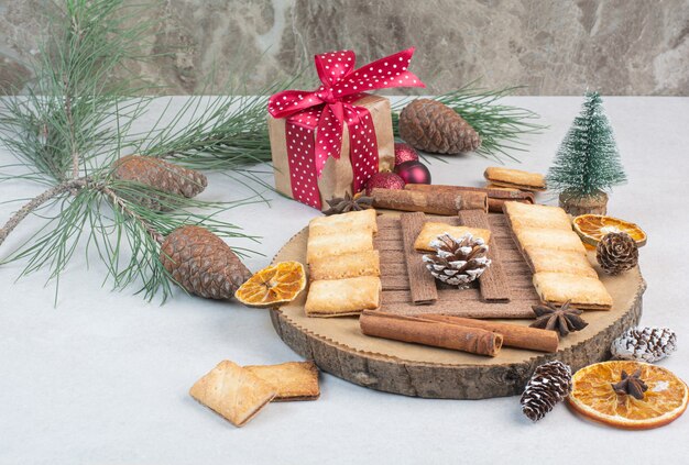 Galletas con aroma canela en rama en placa de madera. Foto de alta calidad