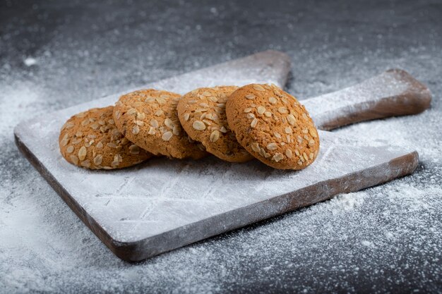 Galletas de avena con azúcar en polvo sobre un fondo negro.