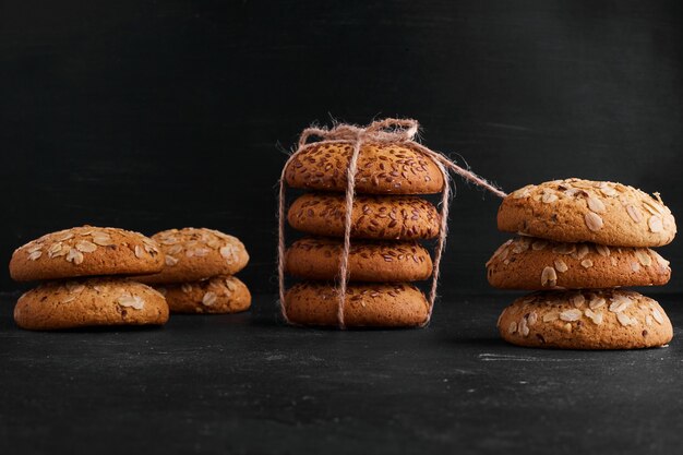 Galletas de avena con comino negro sobre superficie negra.