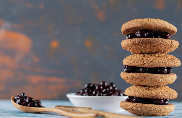 Foto gratuita galletas de avena crujientes con confitura de bayas de grosella negra