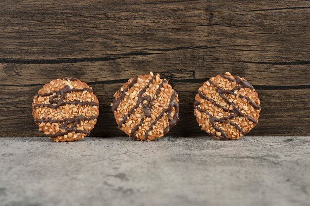 Galletas de avena recién horneadas espolvoreadas con semillas sobre mármol.