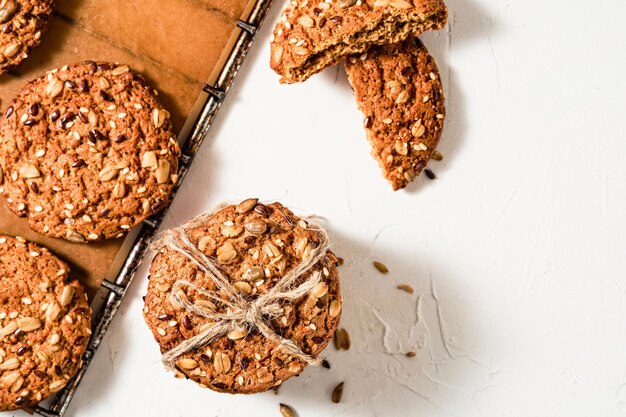 Galletas de avena con semillas de lino y sésamo en una bandeja para hornear, fondo blanco con espacio de copia. Vista superior de galletas horneadas, desayuno saludable. Productos horneados caseros para las fiestas