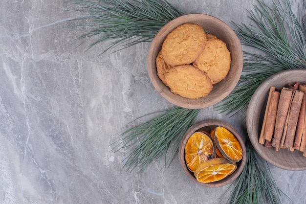 Galletas de avena en una taza de madera con rodajas de canela y naranja