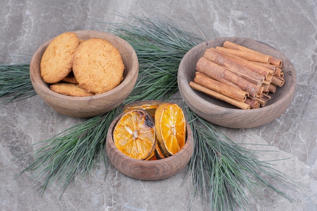 Galletas de avena en una taza de madera con rodajas de canela y naranja