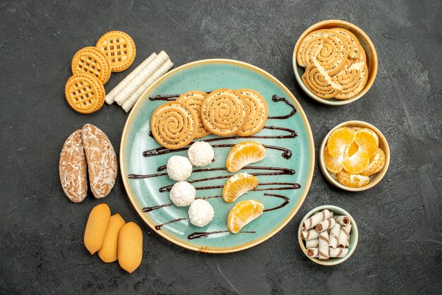 Galletas de azúcar de vista superior con caramelos y galletas sobre fondo gris