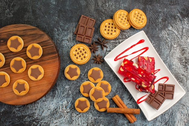 Galletas en bandeja de madera y un plato de chocolate en gris