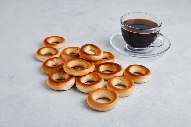 Galletas y bollos aislados en superficie blanca con una taza de café.