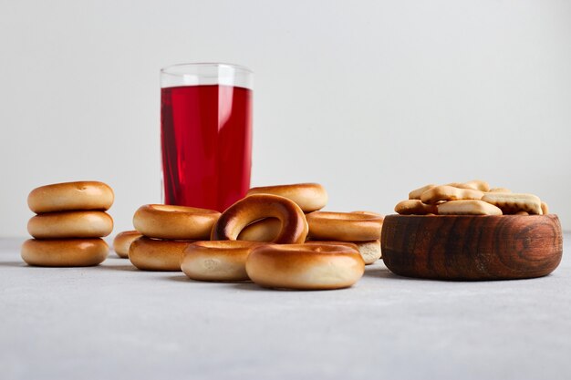 Galletas y bollos servidos con un vaso de jugo.