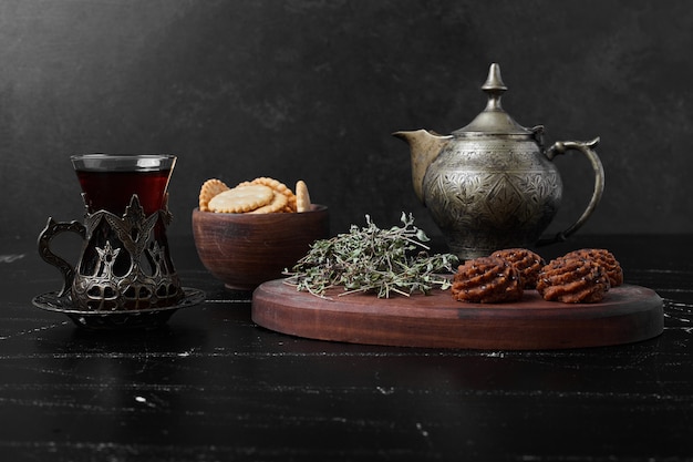 Galletas de cacao y mantequilla sobre una tabla de madera con té.