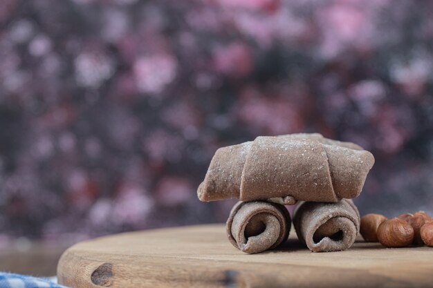 Foto gratuita galletas de cacao mutaki sobre una tabla de madera con avellanas.