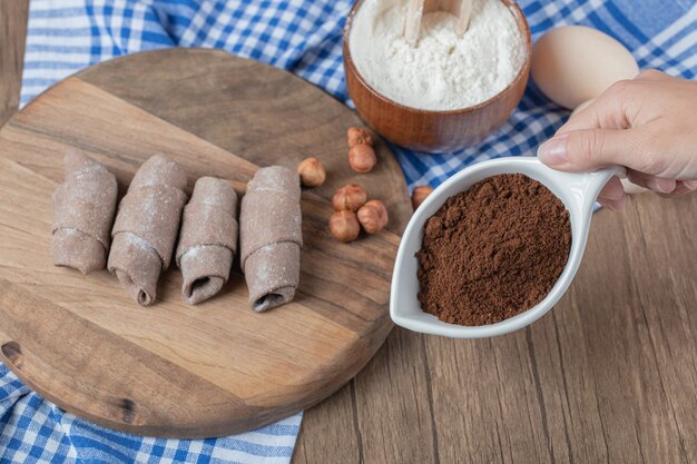 Galletas de cacao mutaki sobre una tabla de madera con canela en polvo.