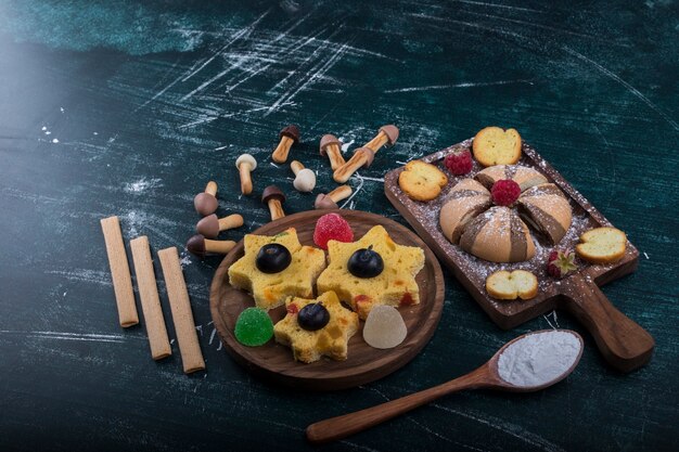 Galletas de cacao y vainilla sobre una tabla de madera con galletas en forma de estrella a un lado