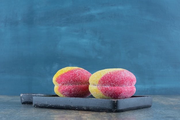 Galletas caseras en forma de melocotón dulce sobre la plancha de madera, sobre la superficie de mármol.