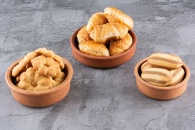 Galletas caseras frescas en cuenco de cerámica sobre gris.