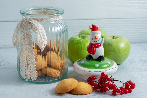 Galletas caseras frescas en el tarro y sobre superficie gris.