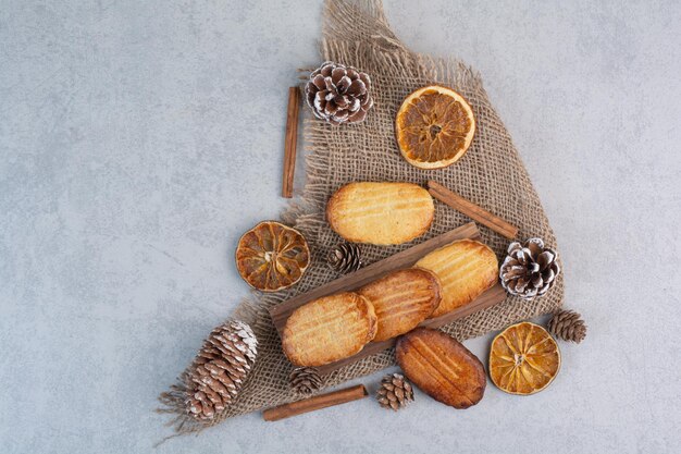 Galletas caseras sobre arpillera con piñas y frutos secos. Foto de alta calidad