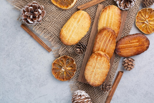 Galletas caseras sobre arpillera con piñas y frutos secos. Foto de alta calidad