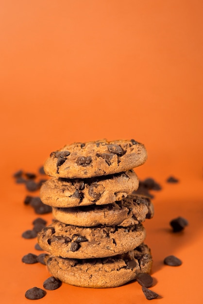 Foto gratuita galletas de chispas de chocolate con fondo naranja