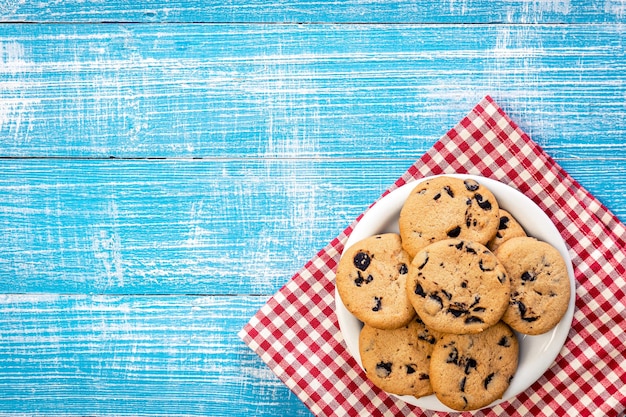 Galletas con chispas de chocolate sobre un fondo de madera plano