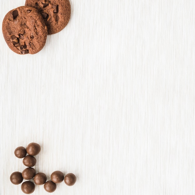 Galletas de chocolate y bola en el fondo de textura de madera