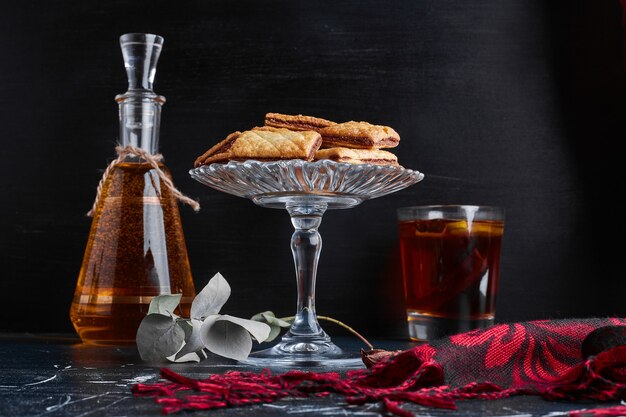 Galletas de chocolate con una botella y un vaso de bebida.