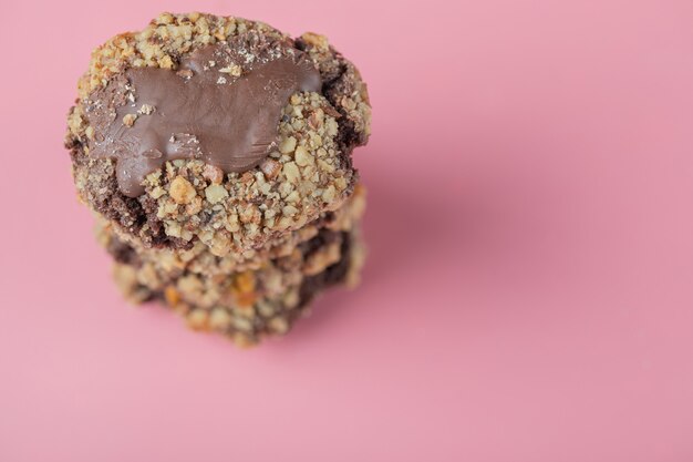 Galletas de chocolate crocante en una mesa rosa.