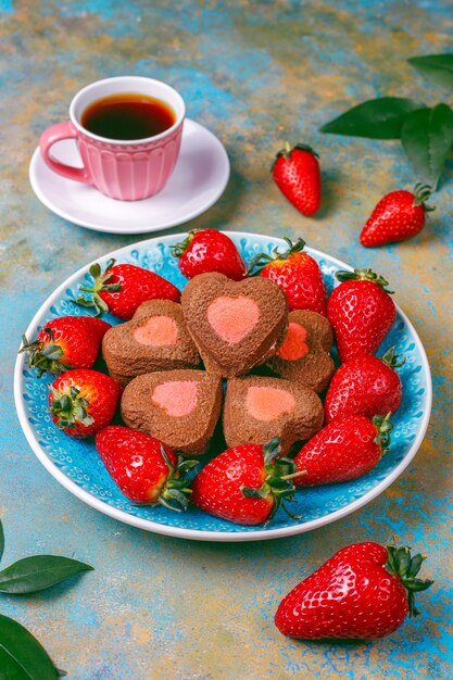 Galletas de chocolate y fresa en forma de corazón con fresas frescas