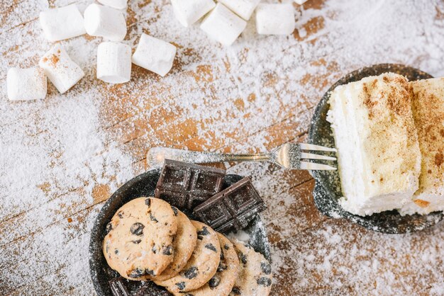 Galletas y chocolate con pastel en mesa decorada.